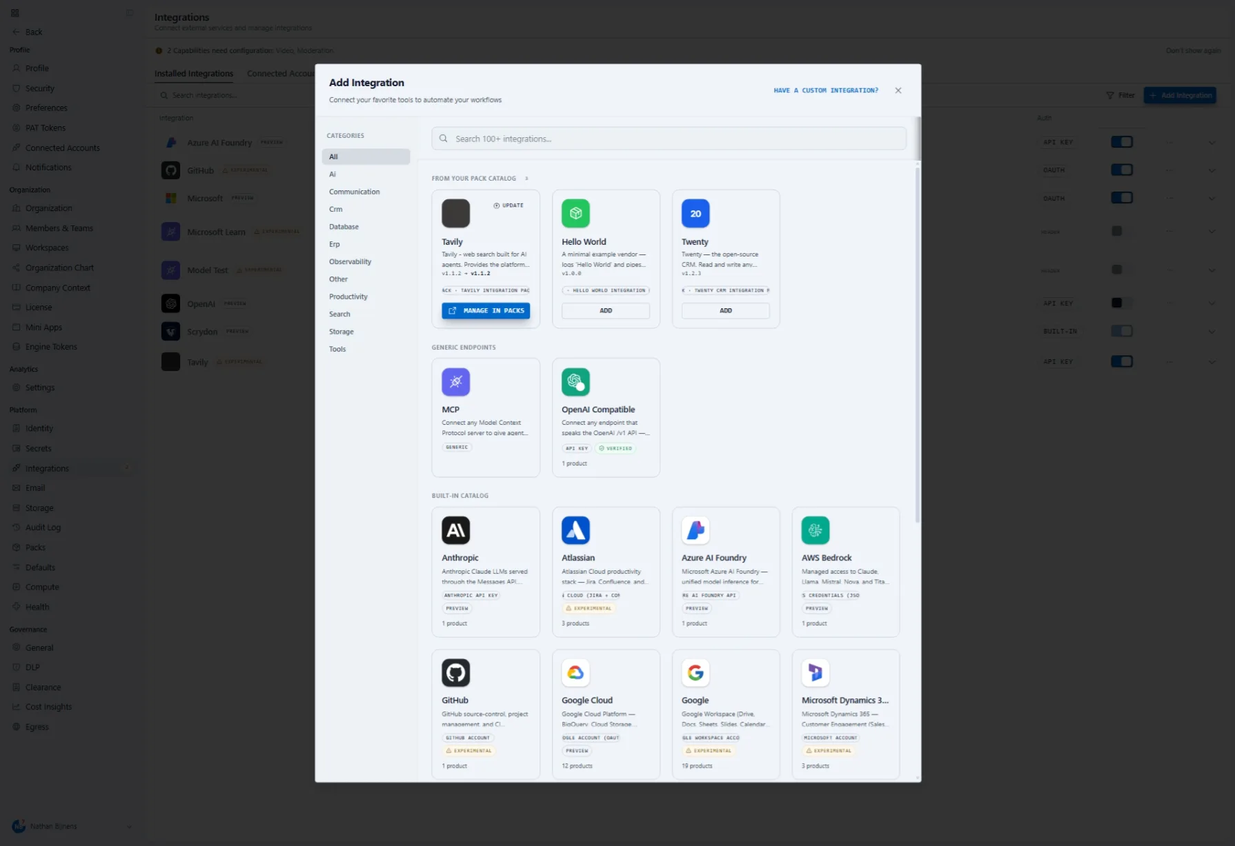 The Add Integration dialogue: a category rail on the left, a search box over a hundred-plus integrations, and three groups — integrations that arrived with your packs, one of them offering an update and a link to manage it in Packs; generic endpoints for any Model Context Protocol server or OpenAI-compatible API; and the built-in catalogue of model providers, cloud platforms, productivity suites and business systems, each card declaring how it authenticates and how many products it covers.